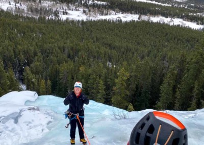 Woman being lowered off of an ice climb after learning to multi pitch ice in the David Thompson Corridor, Alberta