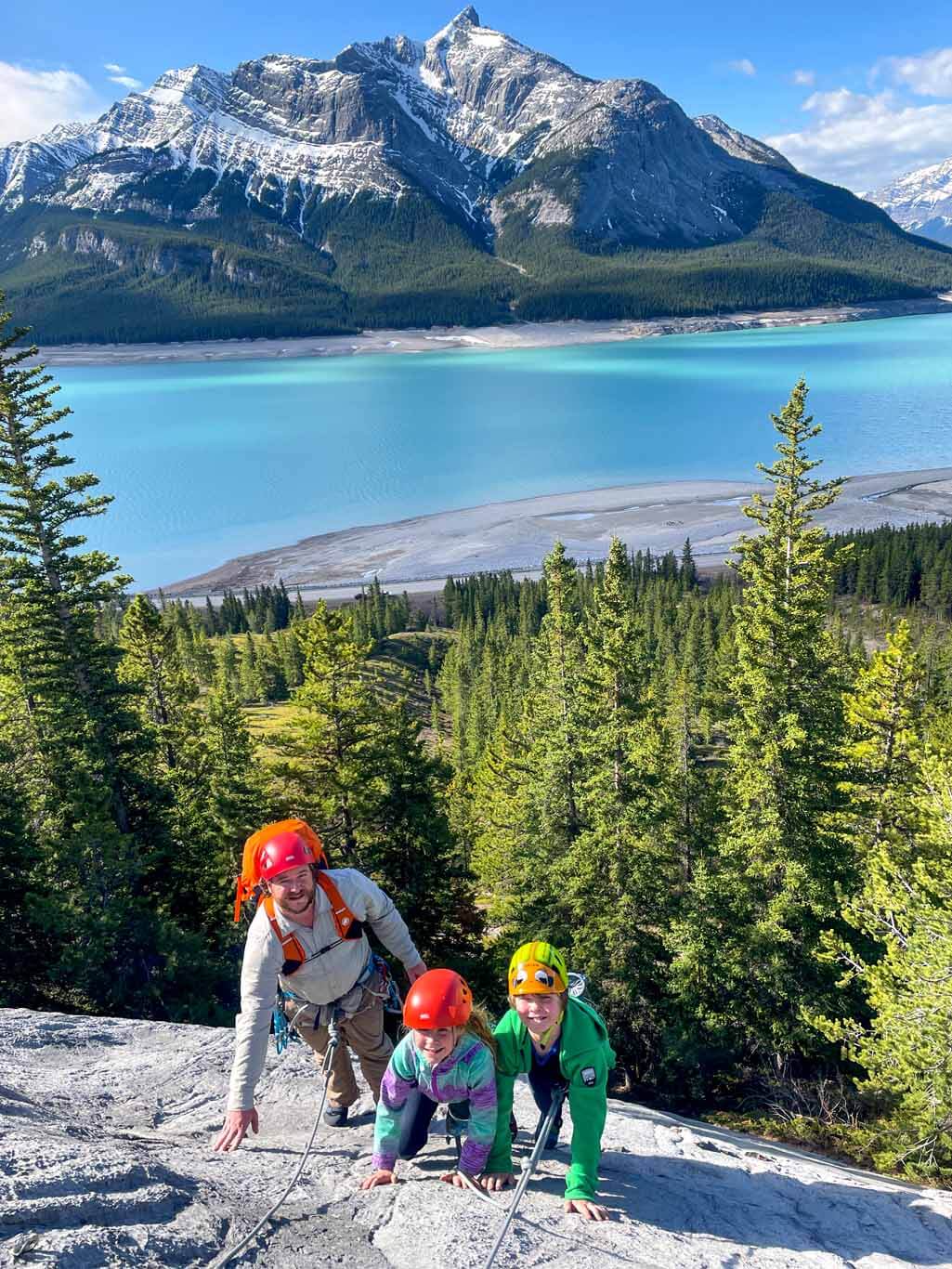 Man and two children multi pitch Rock climbing on the David Thompson Corridor, near Nordegg, Alberta