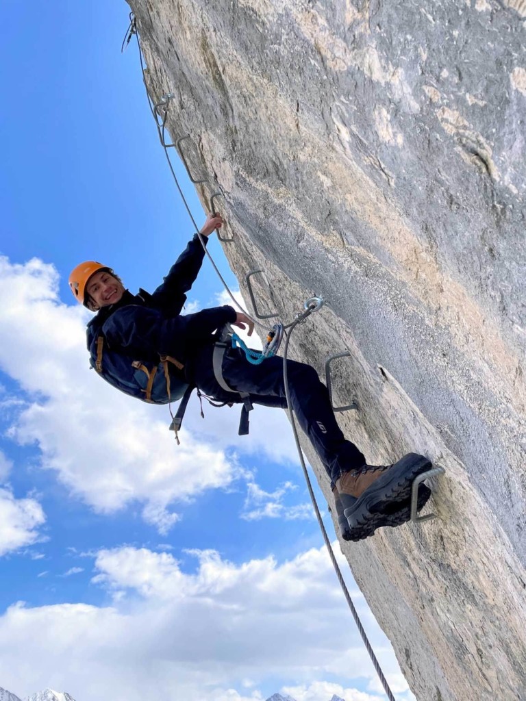 Woman climbing the crux of From Nordegg With Love via ferrata in the Lake Abraham Area, Nordegg Alberta