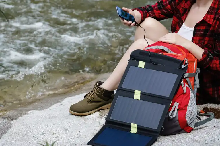 emergency solar panel charging a hikers phone